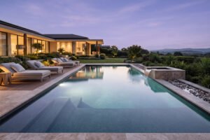 A modern luxury swimming pool showcasing minimalist design, natural stone decking, and calm lighting, representing true architectural balance.